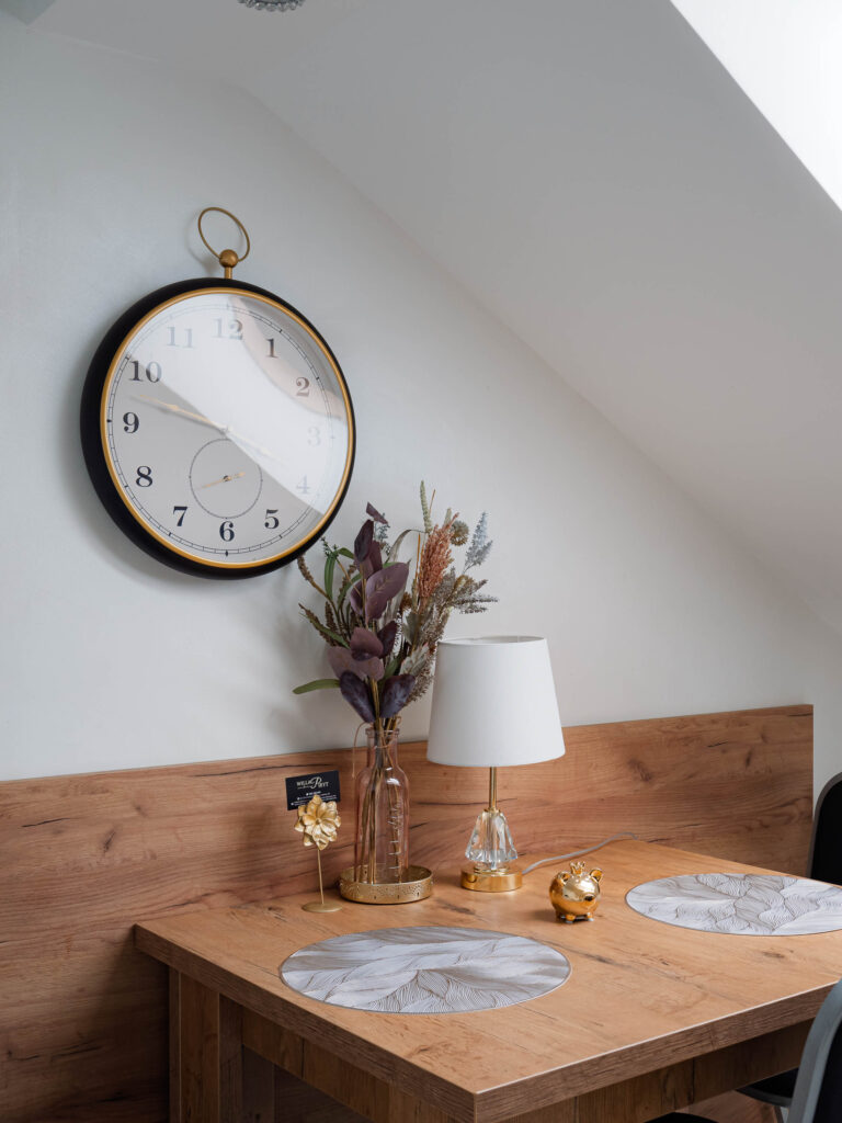 Elegancki stół w apartamencie z dekoracjami, lampką, zegarem i naturalnym wykończeniem