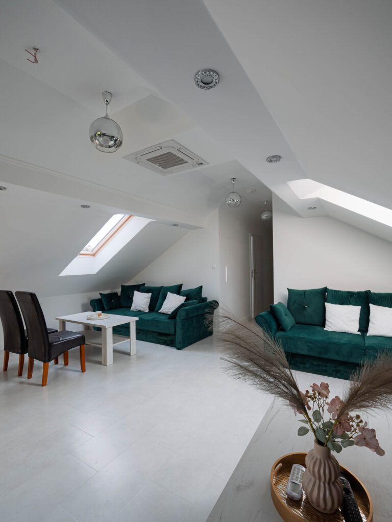 Elegancki apartament z jasnym salonem, turkusową sofą i częścią jadalnianą